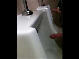 two slim dicks getting wanked at the urinals